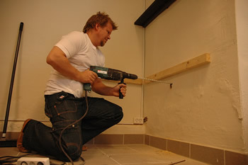 Handy man drilling into wall