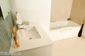 A bathroom's look can be warmed up with a moisture-proof rug and window coverings.